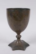 An early Nepalese/Tibetan bronze chalice with a star shaped foot and archaic inscriptions, 17cm high