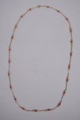 A 9ct gold necklace set with coral beads, 74cm long