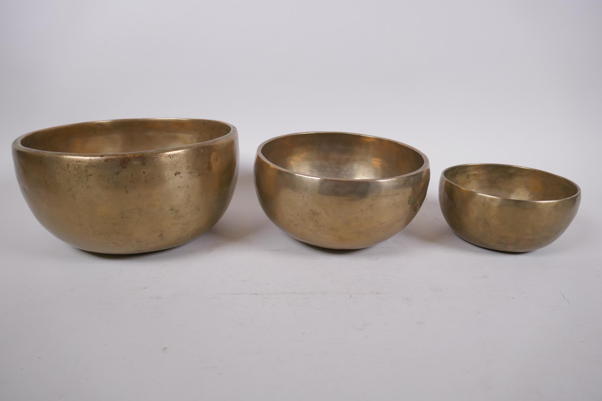 Three Tibetan graduated polished bronze singing bowls with hammered finish, and two wood hammers, - Image 2 of 5