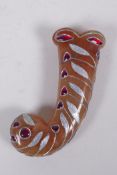 A Murghal style peach hardstone dagger handle with overlaid white metal and red stone decoration,