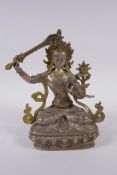 A Tibetan silvered metal figure of Buddha, with gilt highlights, 22cm high