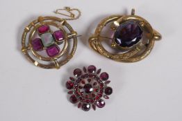 A Victorian yellow metal brooch, set with an amethyst coloured stone, 5.5cm long, a garnet set