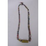 An Islamic multicolour glass bead necklace with a mille fiori feature bead, 88cm long