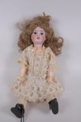 An antique German Schoenau and Hoffmeister bisque headed doll in a white lace dress, marked S PB H