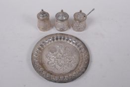 An Indian high purity white metal three piece cruet with repousse decoration, marked T100 to base,