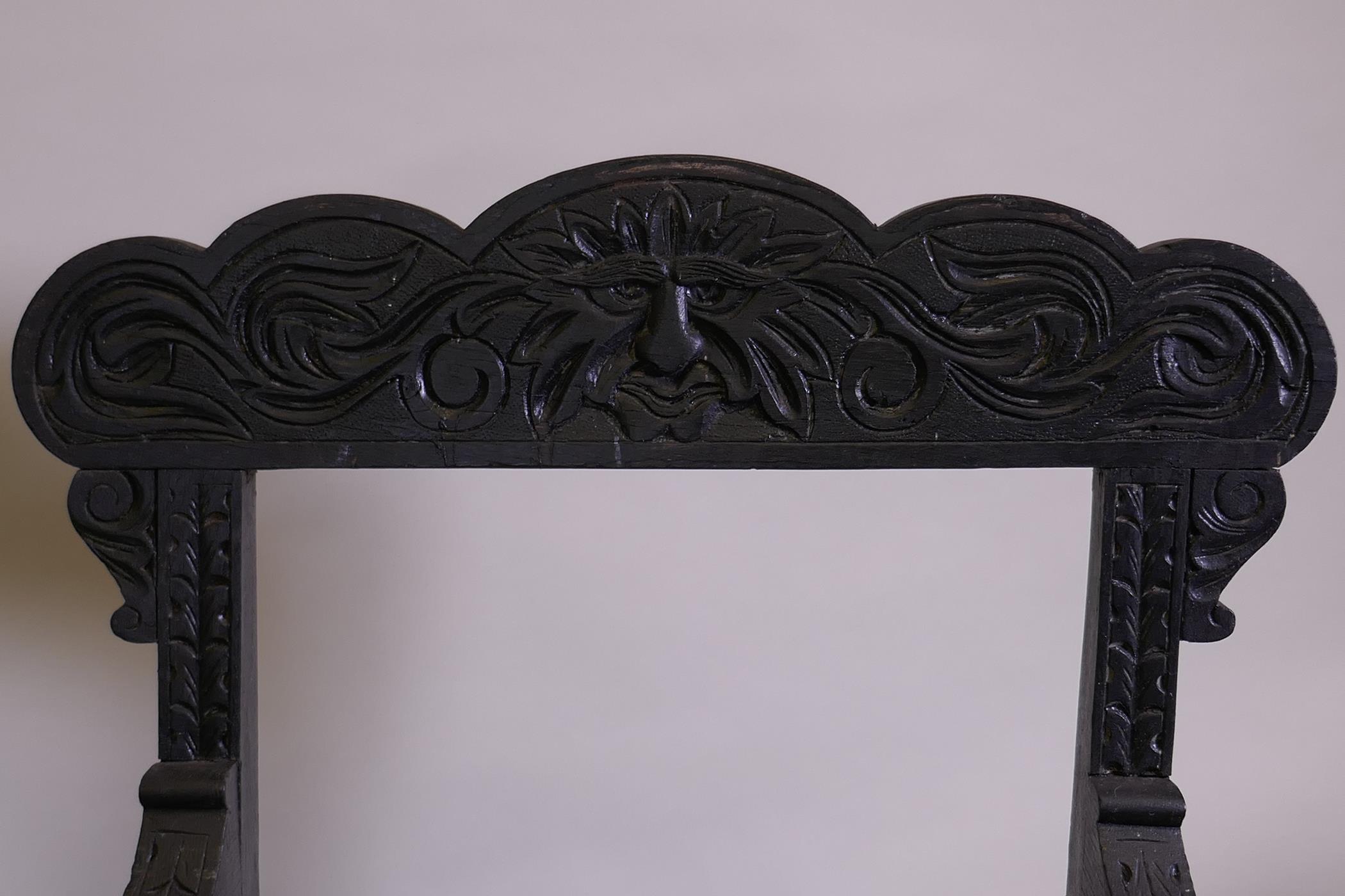 A pair of C19th ebonised X frame chairs with carved Green Man decoration and drop in seats - Image 4 of 4