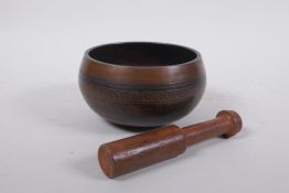 A Tibetan bronze singing bowl with etched decoration and inscriptions, with a wood hammer, 7.5 cm