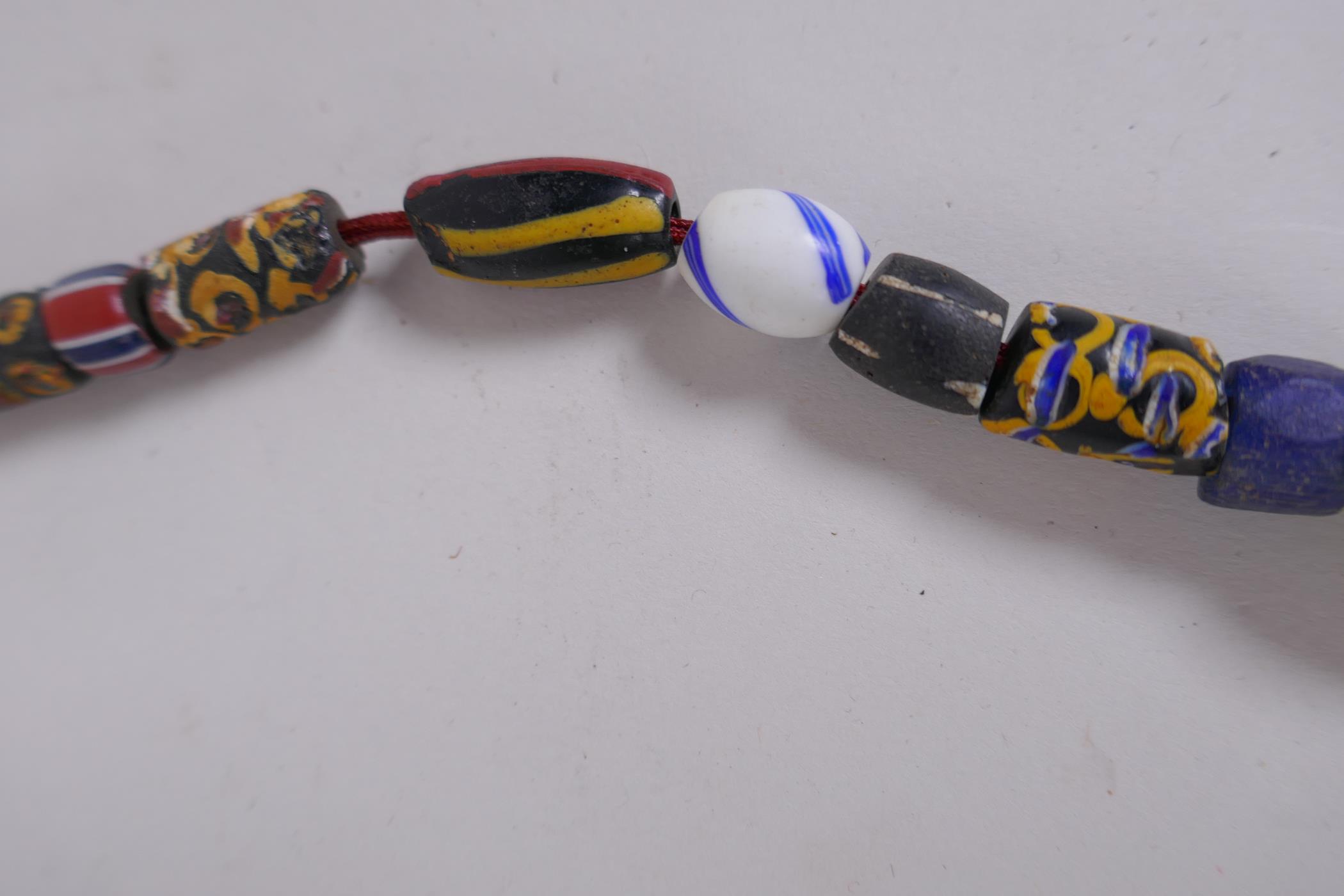 An Islamic multicolour glass bead necklace with a mille fiori feature bead, 88cm long - Image 5 of 6