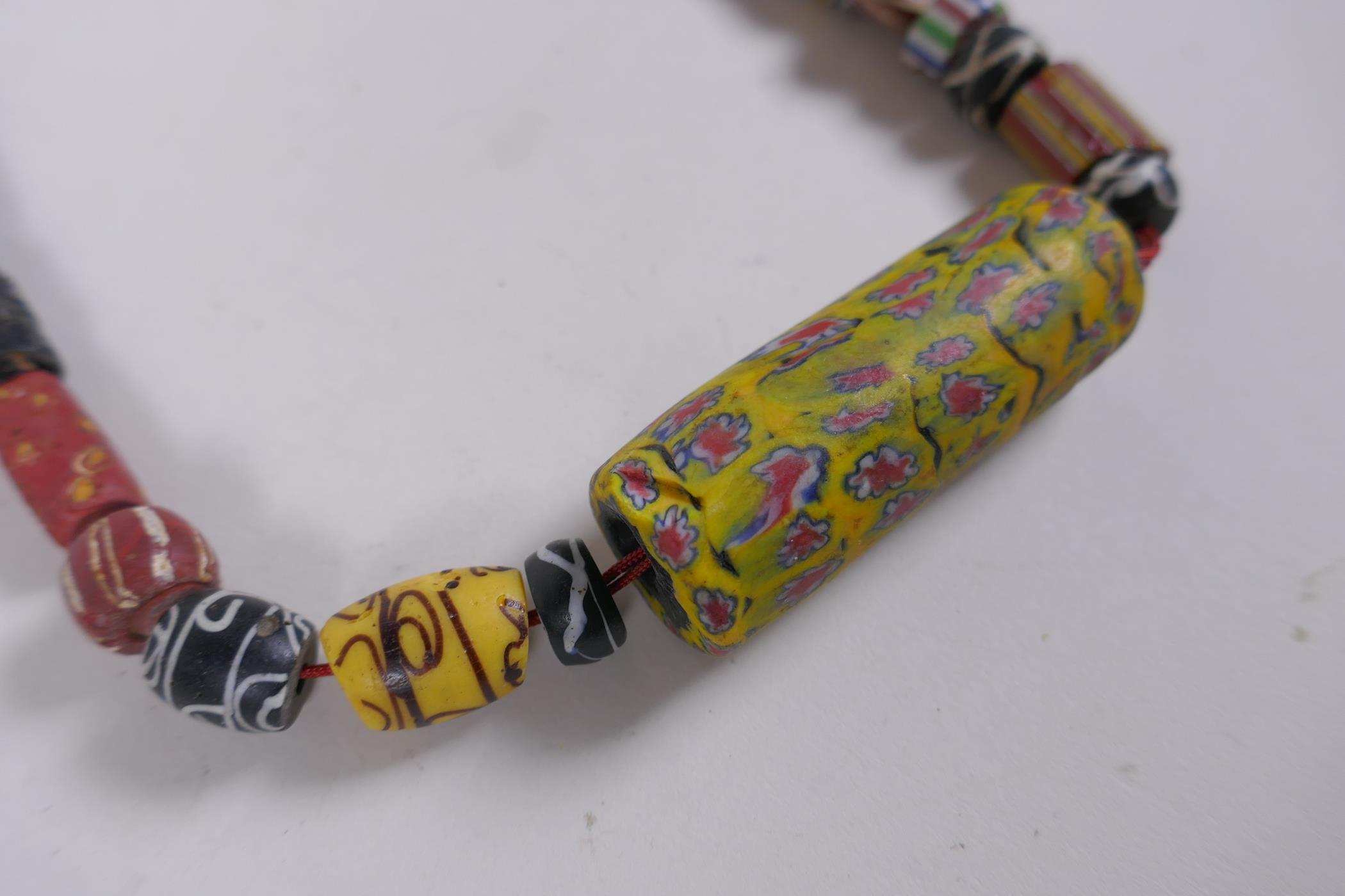 An Islamic multicolour glass bead necklace with a mille fiori feature bead, 88cm long - Image 2 of 6