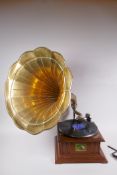 A reproduction HMV gramophone with brass horn, and a collection of 75s, horn 46cm diameter