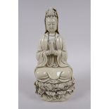 A Chinese blanc de chine porcelain Quan Yin seated on a lotus flower, impressed marks to the