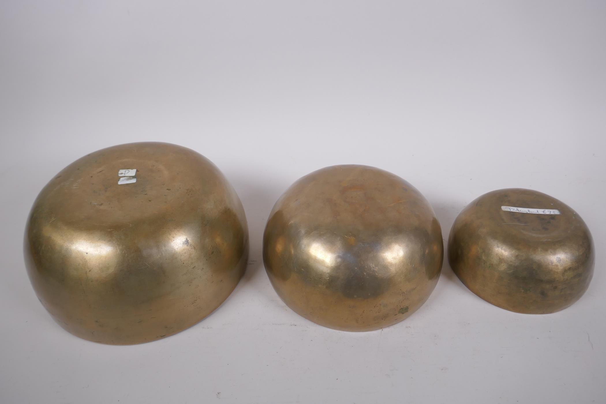 Three Tibetan graduated polished bronze singing bowls with hammered finish, and two wood hammers, - Image 4 of 5