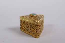 A silver gilt filigree pill box set with a green semi precious stone, marked 925, 3cm