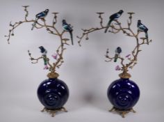 A pair of polychrome porcelain and gilt metal pricket candlesticks decorated with song birds perched