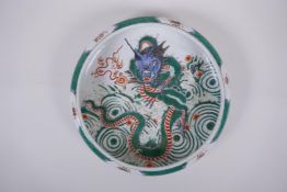 A famille vert porcelain bowl with a rolled rim, decorated with a dragon and flaming pearl,