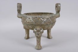 A Chinese archaic style metal censer with two handles, tripod supports and silvered metal