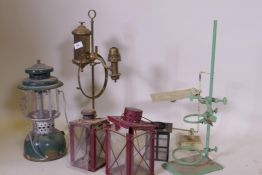 An Akrom pressurised spirit lamp, a brass lamp, garden lanterns AF, and laboratory stands