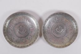 A pair of Chinese white metal coin dishes with zodiac animal decoration