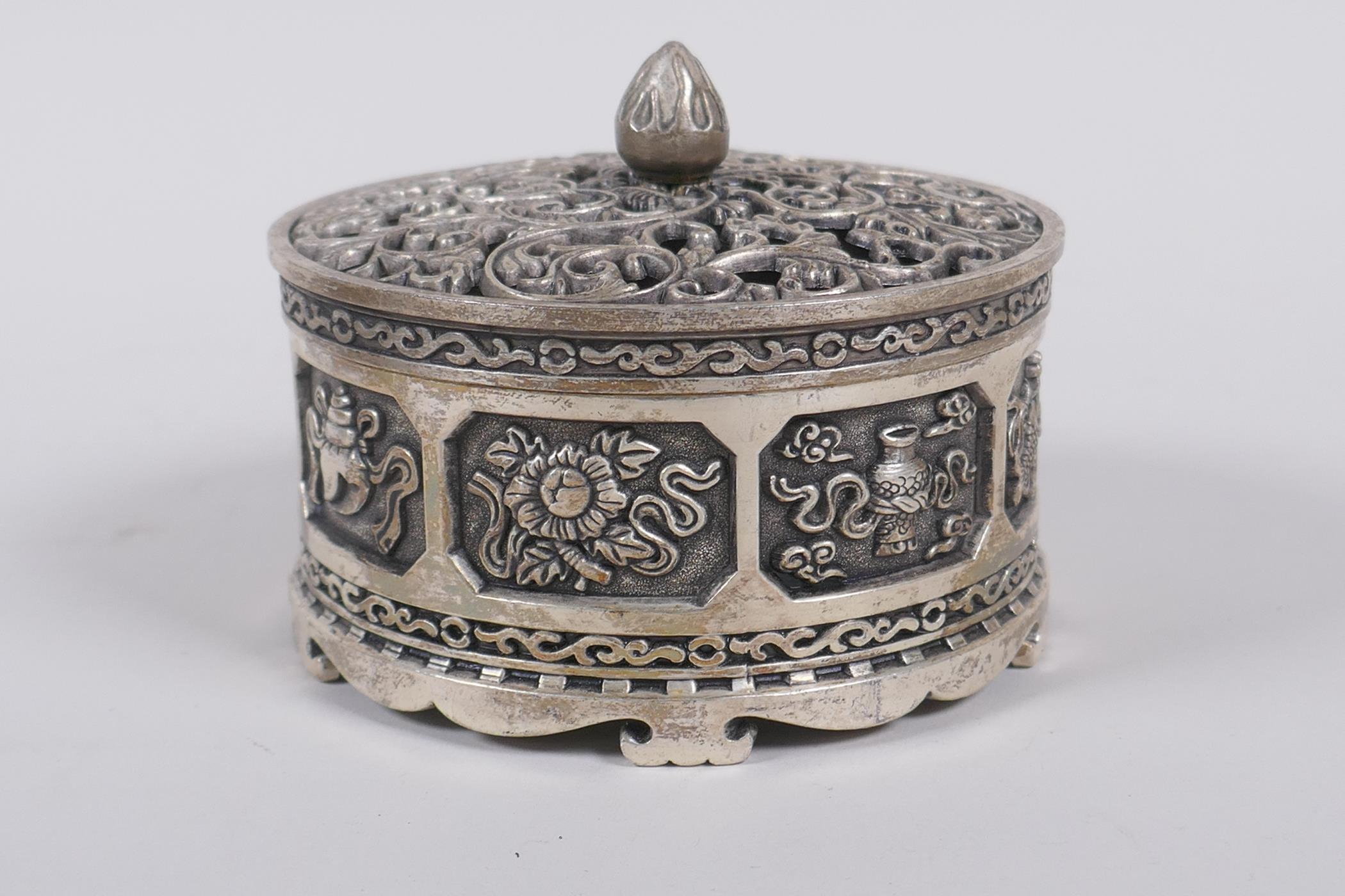 A Sino Tibetan white metal cylinder censer and cover, decorated with the emblems of the eight