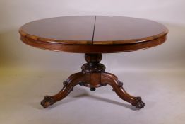 A Victorian rosewood tilt top breakfast table, raised on turned column tripod supports and carved