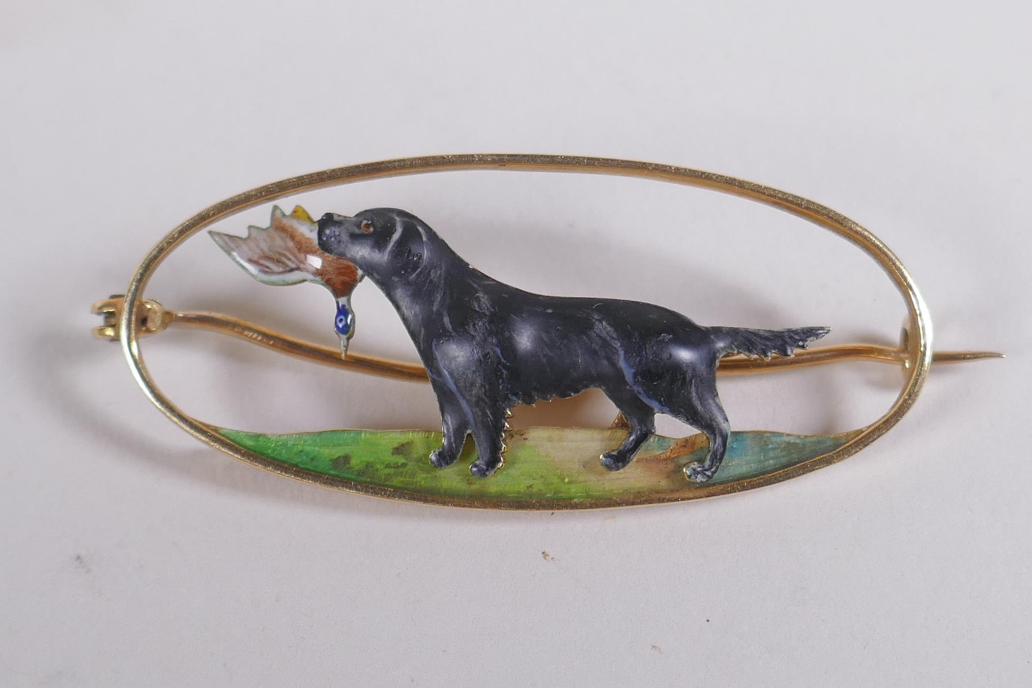 A 15ct yellow gold hunting brooch with overlaid enamel decoration of a gun dog carrying game, the