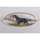 A 15ct yellow gold hunting brooch with overlaid enamel decoration of a gun dog carrying game, the