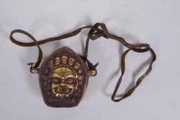 A Tibetan copper gau prayer box, with gilt repousse decoration of a wrathful deity, 6 x 6cm