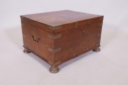 A C19th teak Anglo Indian vanity chest with campaign style brass mounts and handles, raided on brass