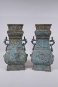 A pair of Chinese archaic style bronze vases with two dragon loop handles, lack bases, 32 cm high