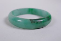 A mottled green jade bangle, 7cm diameter