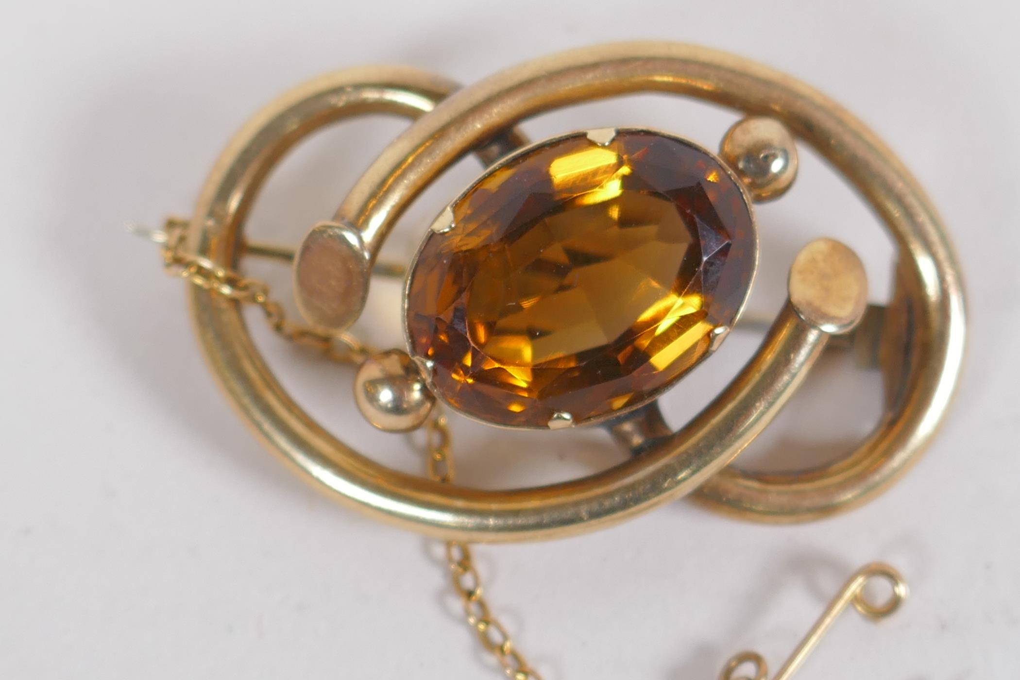 A yellow metal brooch set with a large amber coloured stone, citrine/amethyst, 11.6g - Image 2 of 3