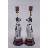 A pair of polychrome porcelain and gilt metal candlesticks in the form of dogs, 34cm high