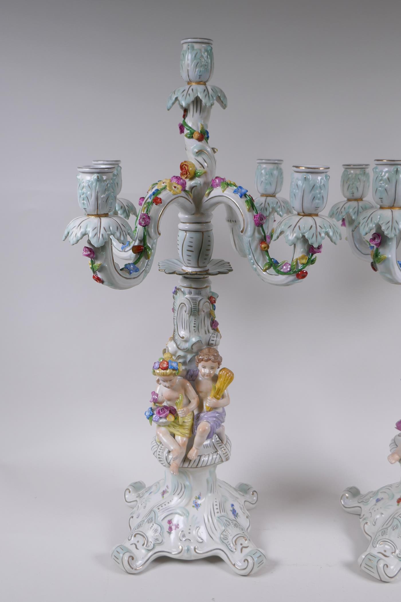 A pair of continental porcelain four branch candelabra decorated with putti, 59cm high - Image 2 of 8