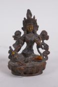 A Tibetan bronze of a female deity seated on a lotus throne, 9cm high