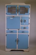 A mid century Stoneham painted kitchen cabinet with glass doors, fall front, three cupboards and