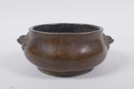 A Chinese bronze censer with Fo dog mask handles, impressed seal mark to base, 12cm diameter