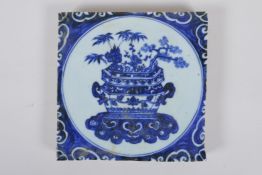 A Chinese blue and white porcelain temple tile decorated with a planter filled with asiatic flora,