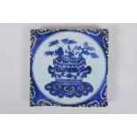 A Chinese blue and white porcelain temple tile decorated with a planter filled with asiatic flora,