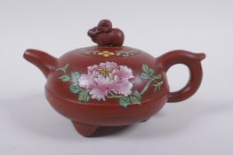 A Chinese Yi Xing teapot on tripod supports with famille rose enamel floral decoration, impressed