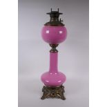 A pink glass and brassed metal oil lamp converted to electricity, 64cm high