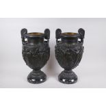 A pair of Grand Tour bronze urns on marble bases, decorated with Greco Roman figures, 41cm high