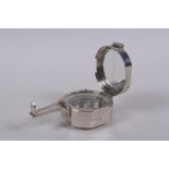 A Brunton style white metal field compass, 6 x 6cm