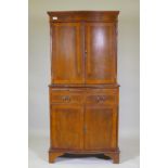 A serpentine front yew wood cocktail cabinet, with two cupboards and mirror back interior,