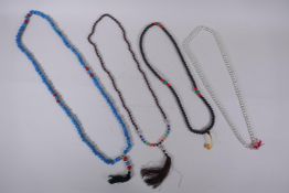 A string of blue and red glass mala beads, a string of tiger's eye mala beads, a string of dried