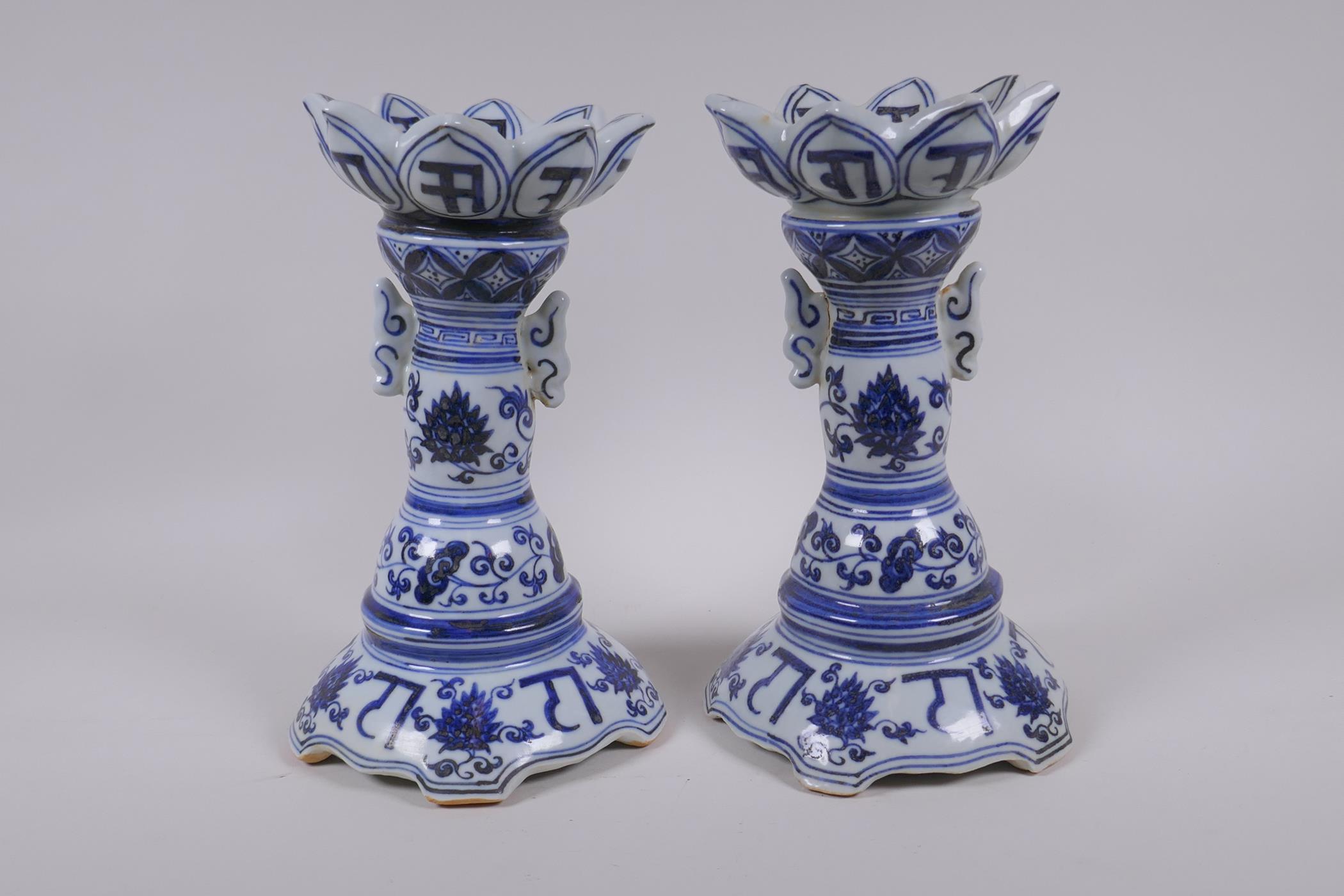 A pair of Chinese blue and white porcelain candlesticks of lotus flower form, with two handles and