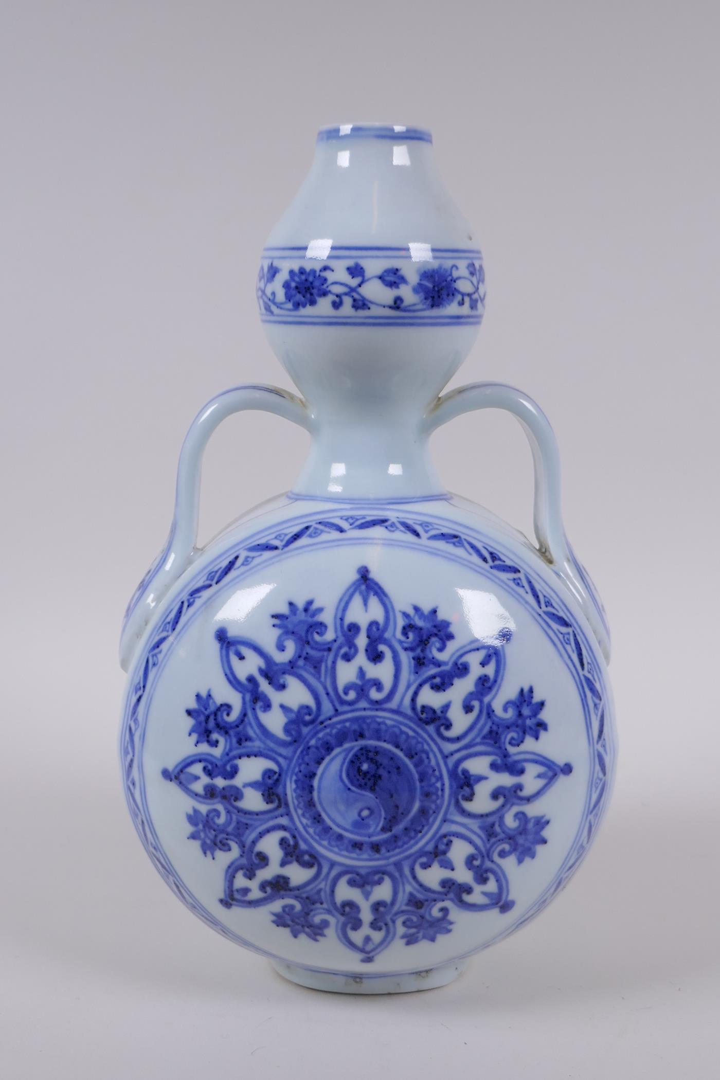 A blue and white porcelain garlic head shaped flask with two handles and Yin Yang decoration,