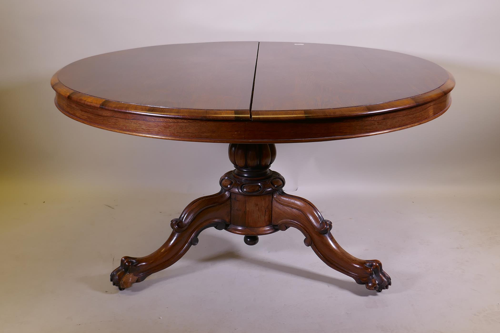 A Victorian rosewood tilt top breakfast table, raised on turned column tripod supports and carved