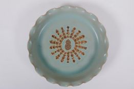 A Chinese celadon glazed porcelain dish with frilled rim and impressed character inscription to