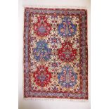 An Iranian cream ground wool rug with blue and red panelled design, 112 x 156cm