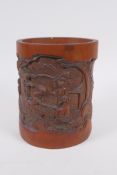 A Chinese carved bamboo brush pot decorated with figures playing go, 16cm high